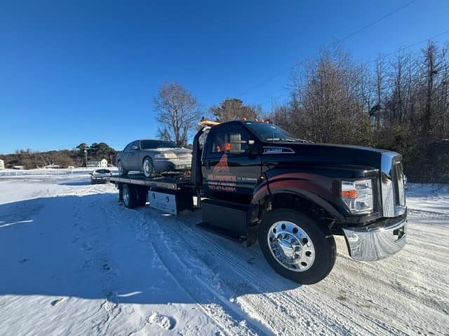 Silverback tow truck towing a car across a snow covered lot