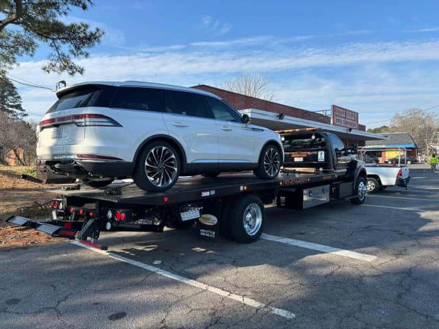 White luxury SUV transported on the Silverback flatbed tow truck