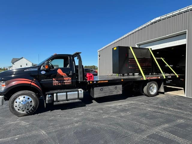 The Silverback F-750 rollback parked outside a repair shop bay