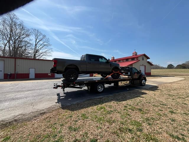 Black pickup on the Silverback flatbed in front of a red barn