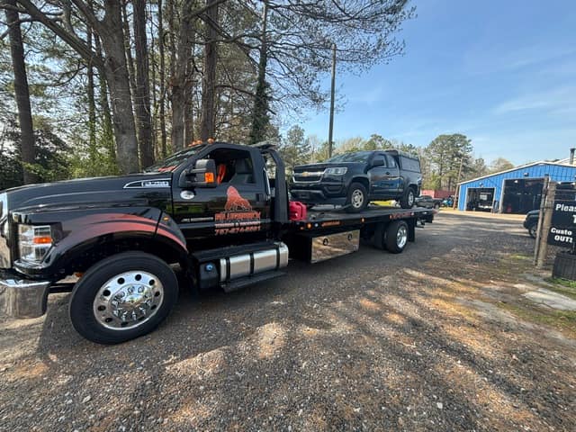 Black SUV loaded on the Silverback flatbed among the pines