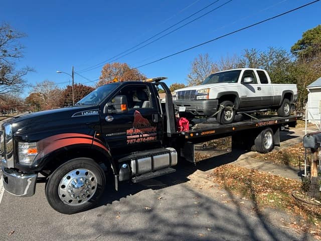 White Chevy pickup towed on the Silverback F-750 rollback