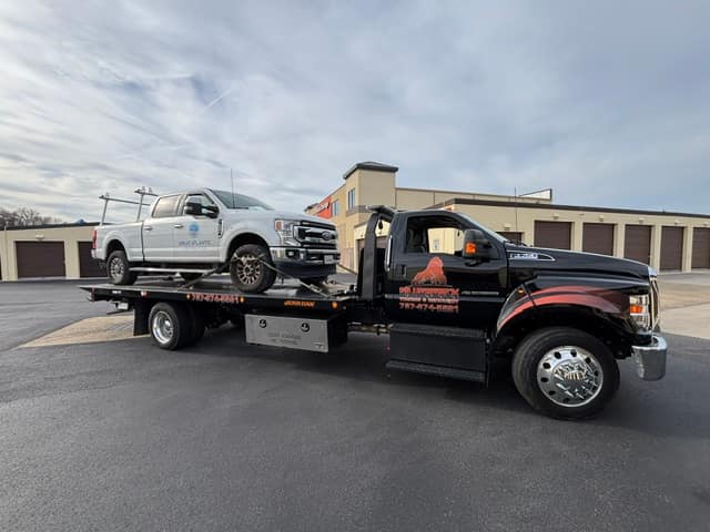 White Ford Super Duty pickup on the Silverback rollback in a parking lot