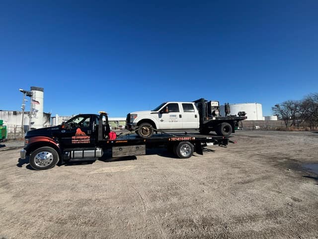 White work truck towed on the Silverback flatbed