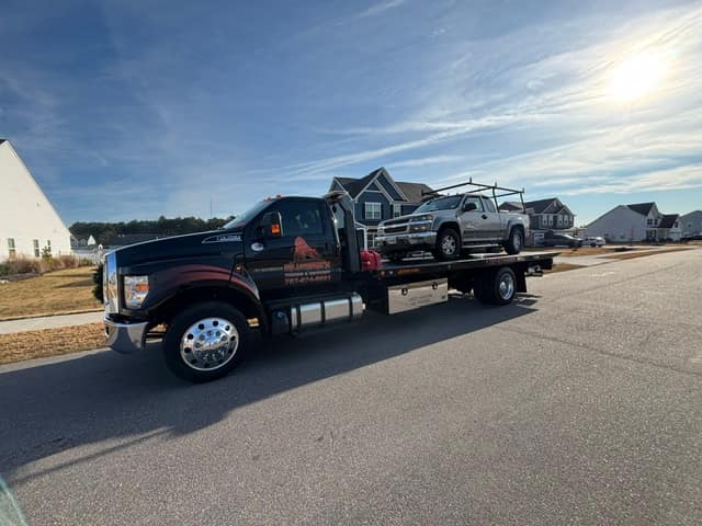 Work pickup with a ladder rack towed on the Silverback flatbed